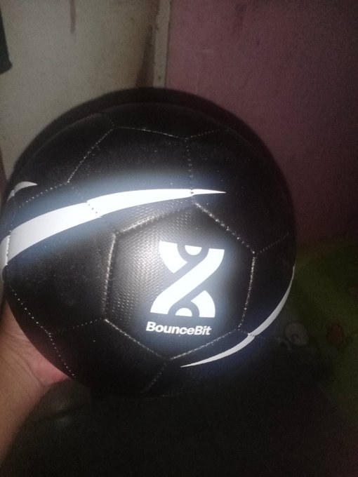 A black and white soccer ball branded with the 'BounceBit' logo being held by hand.