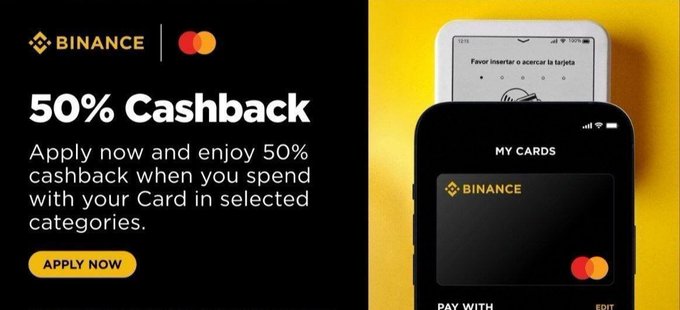 The image shows a black smartphone displaying an advertisement for Binance, which offers users the opportunity to receive 50% Cashback on purchases made with their credit card. The phone is positioned diagonally across the image against a yellow background. The text above the phone reads "Binance Virtual Card Coming Soon! Your crypto, your money, your way" and below it states that Binance allows users to spend up to 75% of their selected categories in virtual currency without the need for an ATM or bank transfer fees.