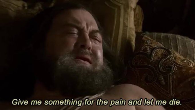 A dramatic movie scene showing a bearded man in distress with the subtitle reading, "Give me something for the pain and let me die."