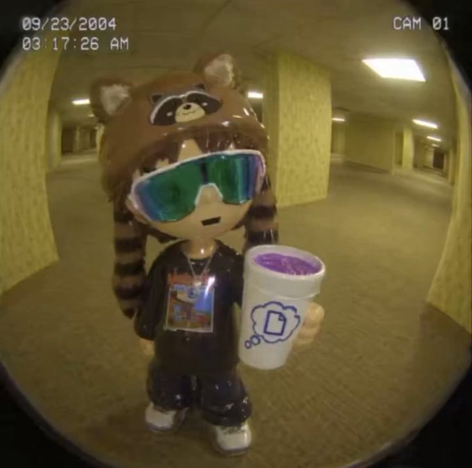 A surveillance camera screenshot dated 09/23/2004 at 03:17:26 AM showing a customized figurine with a raccoon hat, green goggles, and a purple bubble tea cup standing in an empty parking garage.