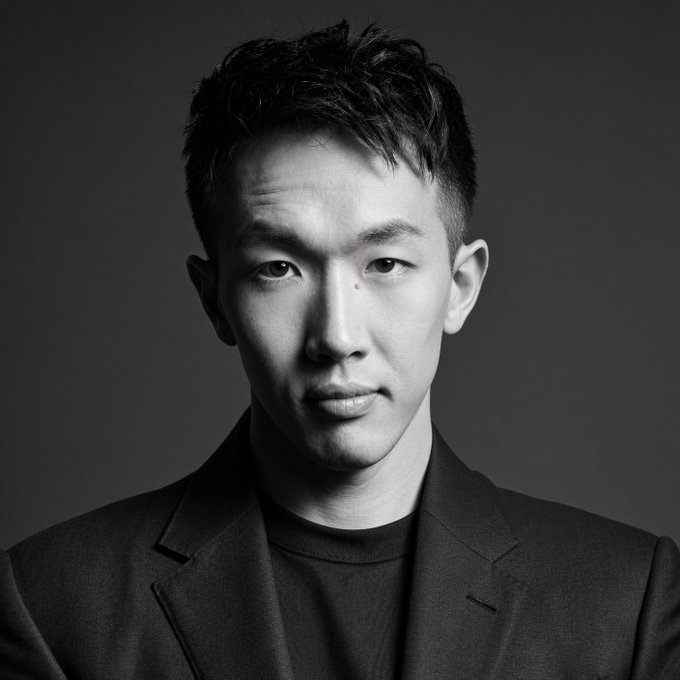 A black-and-white portrait of an Asian man in a blazer gazes directly at the camera. The image likely represents VirtualBacon, the crypto analyst referenced in the post as expressing bullish potential for $ADA and $NIGHT.