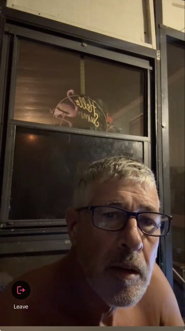 A close-up selfie of a shirtless older man with gray hair and glasses, with a 'Leave' button visible, suggesting a video call or live stream interface.