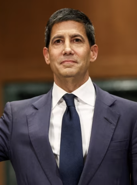A man in a navy suit and tie appears serious, likely a financial commentator or executive, paired with a warning about the Federal Reserve's pattern of multiple rate hikes per cycle and market repricing from expected cuts to anticipated increases.