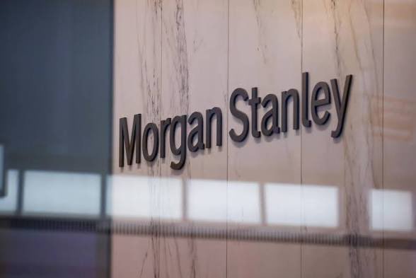 The image shows the Morgan Stanley logo displayed in metallic lettering on a marble wall, likely at the entrance of a corporate office or building. The polished, upscale presentation of the signage aligns with the post's "Higher" theme, suggesting positive performance or growth associated with the financial institution.