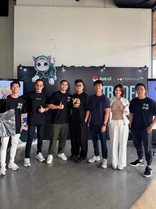 A group of seven people pose together at a corporate event in front of a backdrop featuring a cartoon cat mascot and logos for Ave.ai and Hyperliquid.