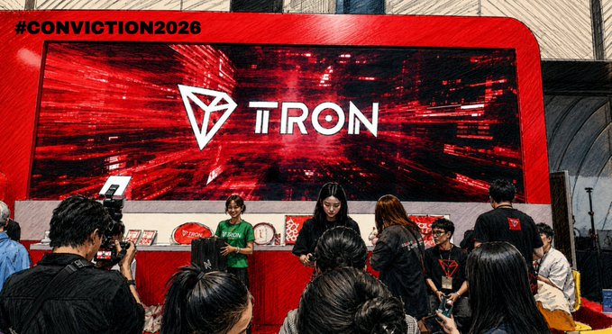 A crowded event booth at #CONVICTION2026 featuring a large red screen displaying the "TRON" logo, with staff in TRON-branded shirts and attendees gathered around the display.