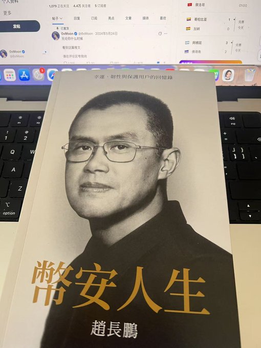 A book titled "靜安人生" (Jing'an Life) by 超長鵬 sits on a keyboard in front of a monitor displaying Weibo and other social media feeds, showing the Chinese edition won through a giveaway event by @FOMA_BSC. The post humorously suggests pairing it with cousin @cz_binance for a charity promotion while awaiting the English translation.