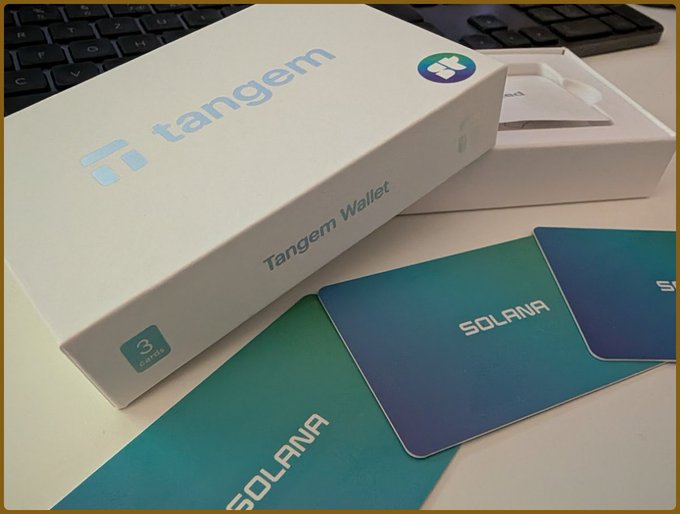 A Tangem Wallet box for Solana cryptocurrency, shown open with branded cards fanned out next to it.