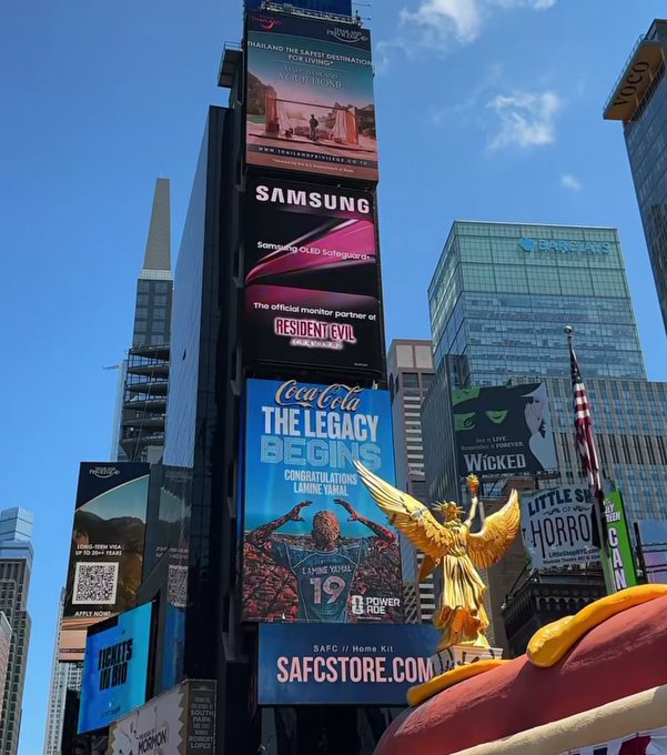 A street view in Times Square features multiple billboards, including Samsung advertising OLED Safeguards and Resident Evil, Coca-Cola's 'The Legacy Begins' congratulating Lahine Vahal (#19), and a Wicked musical poster.