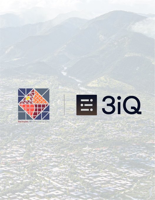 An aerial view of a city nestled in mountains serves as the background for logos for 'Gelephu Mindfulness City' and '3iQ'.