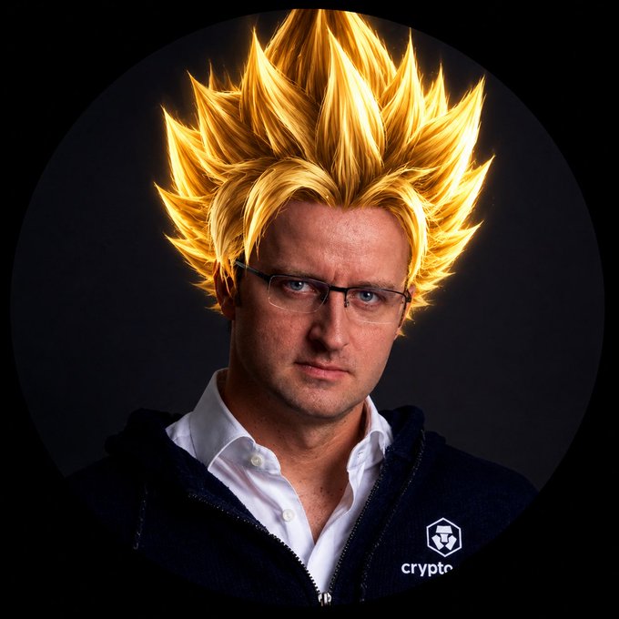 A man with glasses wearing a dark Crypto.com hoodie, his head edited with spiky golden hair in the style of a Super Saiyan from Dragon Ball Z.