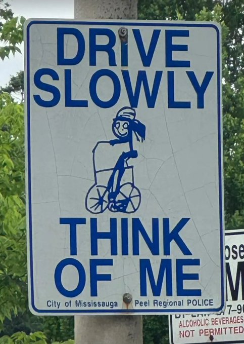 A street sign from the City of Mississauga and Peel Regional Police that reads 'DRIVE SLOWLY THINK OF ME,' featuring a blue illustration of a young girl riding a bicycle.