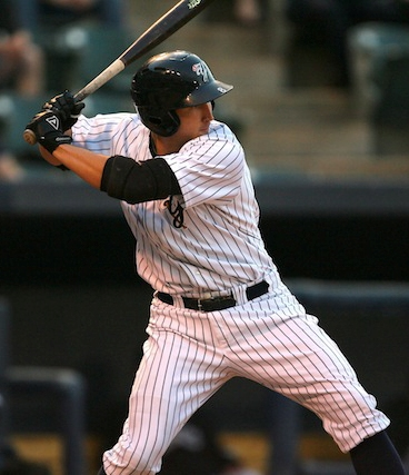 A focused baseball player in a pinstriped uniform completes his swing, his black bat extended behind him as he follows through after making contact. The image perfectly captures the decisive moment of "swinging for the home run," with the batter's powerful stance and concentrated expression embodying the all-or-nothing mentality described in the caption.