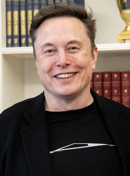 The image features a man wearing a black shirt with a car design, smiling for the camera. The caption below his photo reads "LATEST: Elon Musk is now worth more than Bitcoin", which suggests that the value of the man's name has increased significantly in recent years due to the rise of Tesla and other companies associated with him.