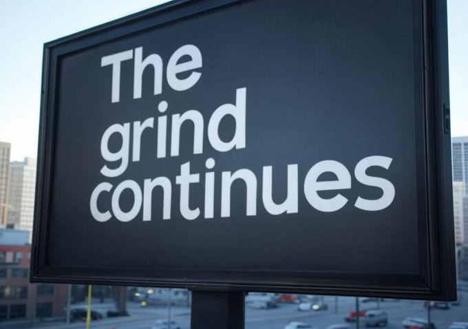 The image features a billboard sign that reads "The Grind Continues" written in white letters against a black background. The text is positioned at the bottom of the sign, making it easily visible for passersby. Below the main message, there's an additional line of text that says "@Aave V4 exploring deployment on Arc". This suggests that the billboard might be promoting a new financial technology or service related to lending and borrowing in the cryptocurrency world. The image captures the attention of viewers with its bold white letters against a black background, making it stand out from other elements in the scene.