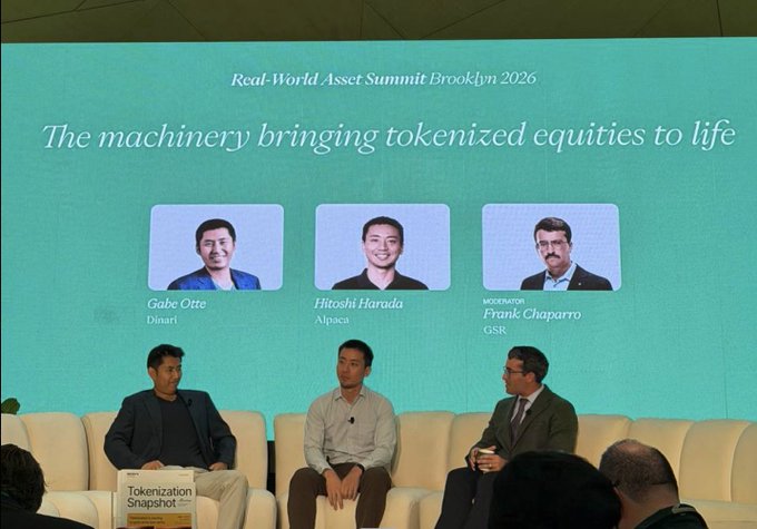 Dinari co-founder Gabe Otte sits on stage at the Real-World Asset Summit Brooklyn 2026 alongside Hitoshi Harada of Alpaca, moderated by GSR's Frank Chaparro, during a panel titled "The machinery bringing tokenized equities to life," as referenced in the accompanying post.