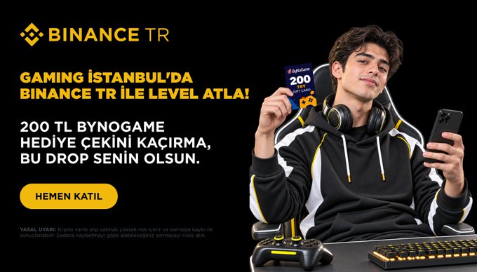 A young gamer in a black and yellow hoodie holds up a 200 TL Binance TR BynoGame gift card while sitting with gaming headphones, phone, controller, and keyboard, promoting Binance TR's "Gaming Istanbul" campaign offering a free 200 TL digital game code for first-time traders.