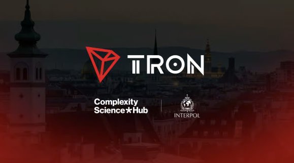 The image features the TRON logo prominently displayed over a darkened cityscape backdrop, alongside the "Complexity Science Hub" and "INTERPOL" logos, visually representing TRON's participation in the INTERPOL New Technologies Forum in Vienna as referenced in the accompanying post about blockchain-based decentralized finance discussions.