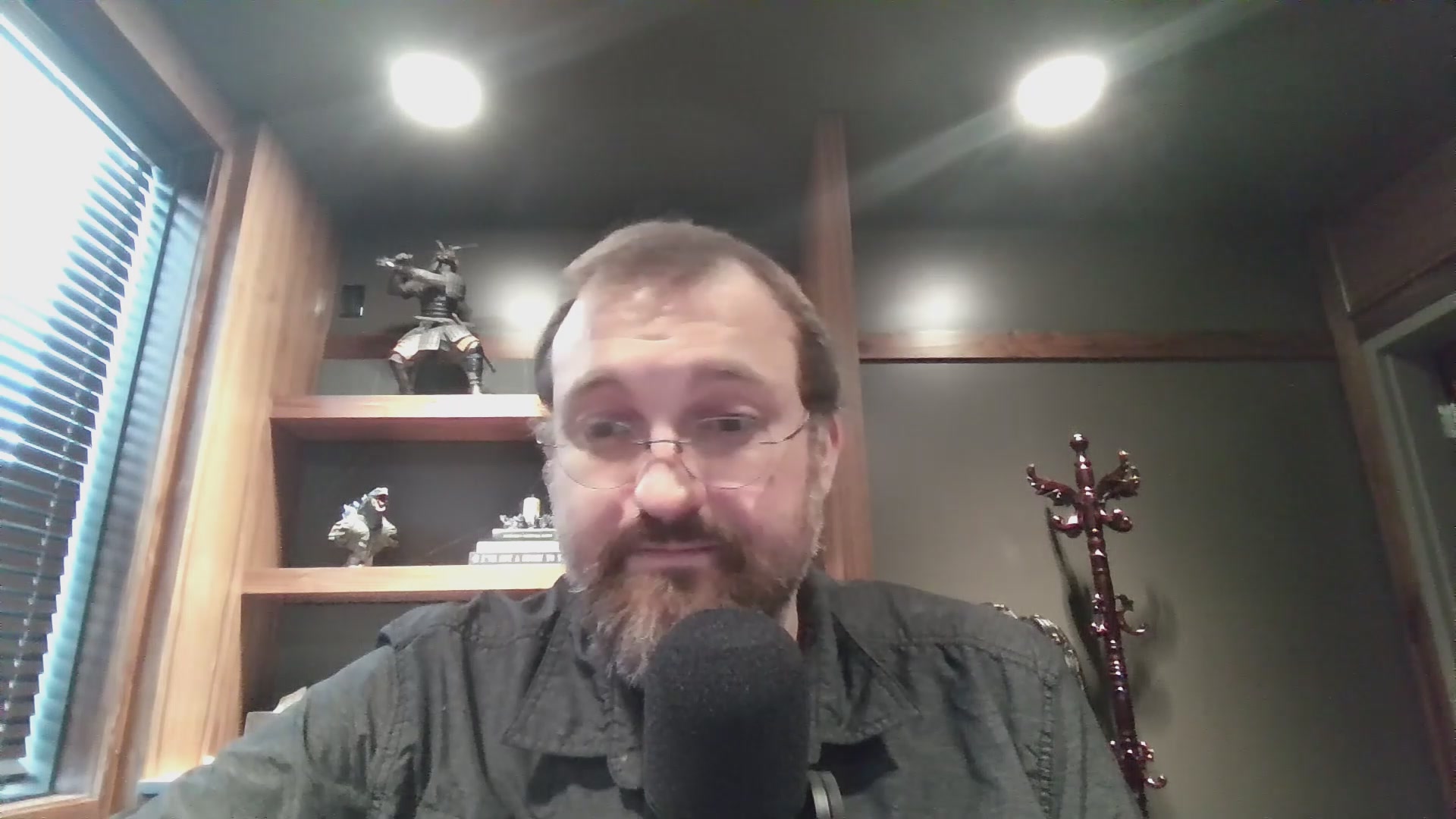The image features a bearded man wearing glasses sitting at a desk with a microphone in front of him. The man appears to be talking into the microphone or recording a video call. The background includes a window, suggesting that he might be indoors or near an office setting. The caption reads "Regardless of one's opinion on the success or lack thereof of $ADA, Hoskinson is a man who dedicates sweat and tears to crypto, and that should be respected." This message seems to be related to the image as it could be a part of a discussion about cryptocurrency or the importance of respecting others' opinions.