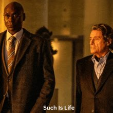 Two men in suits (appears to be a scene from a TV show) with the caption 'Such Is Life' at the bottom.