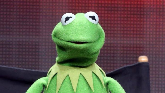 Kermit the Frog, the green Muppet character, sits in a chair with his eyes looking off to the side.