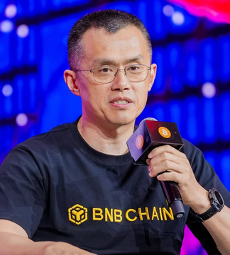 A man with glasses, wearing a black "BNB CHAIN" t-shirt, speaks into a microphone at an event with a blue-lit background. The image aligns with the post's theme of viewing Bitcoin and AI as enduring technological utilities rather than exit-based investments.