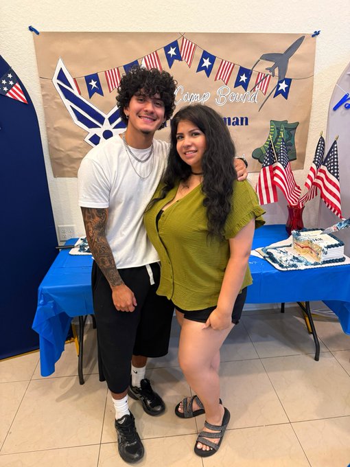 A young man and woman pose together in front of an Air Force-themed 'Camp Bound' banner decorated with American flags and a jet aircraft silhouette, suggesting a military send-off celebration.