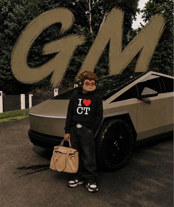 A person wearing a black 'I ❤️ CT' hoodie stands in front of a silver Tesla Cybertruck holding a tan designer handbag, with large gold 'GM' letters in the background.