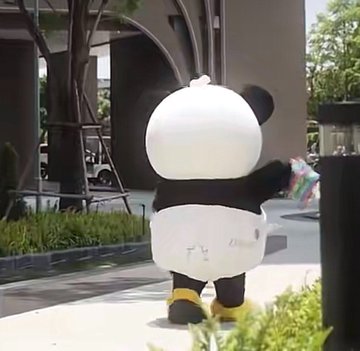 A person in an inflatable panda costume with a notably round head stands outdoors in a sunny plaza setting. The post references "Dot Period #LUNAR," suggesting this whimsical scene may be related to a playful lunar-themed concept or brand activation featuring the costumed character.