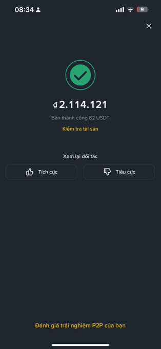 A mobile app screen in Vietnamese confirming a successful trade of 82 USDT, displaying a balance of ₫2,114,121 with options to check assets and rate the transaction as positive or negative.