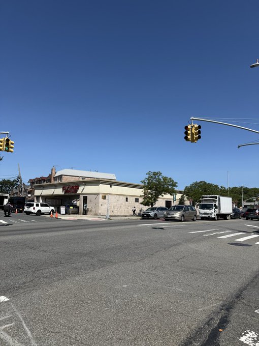 A street view photograph of a corner building labeled 'Peppa's' at an intersection with traffic lights, parked cars, a delivery truck, and a clear blue sky.