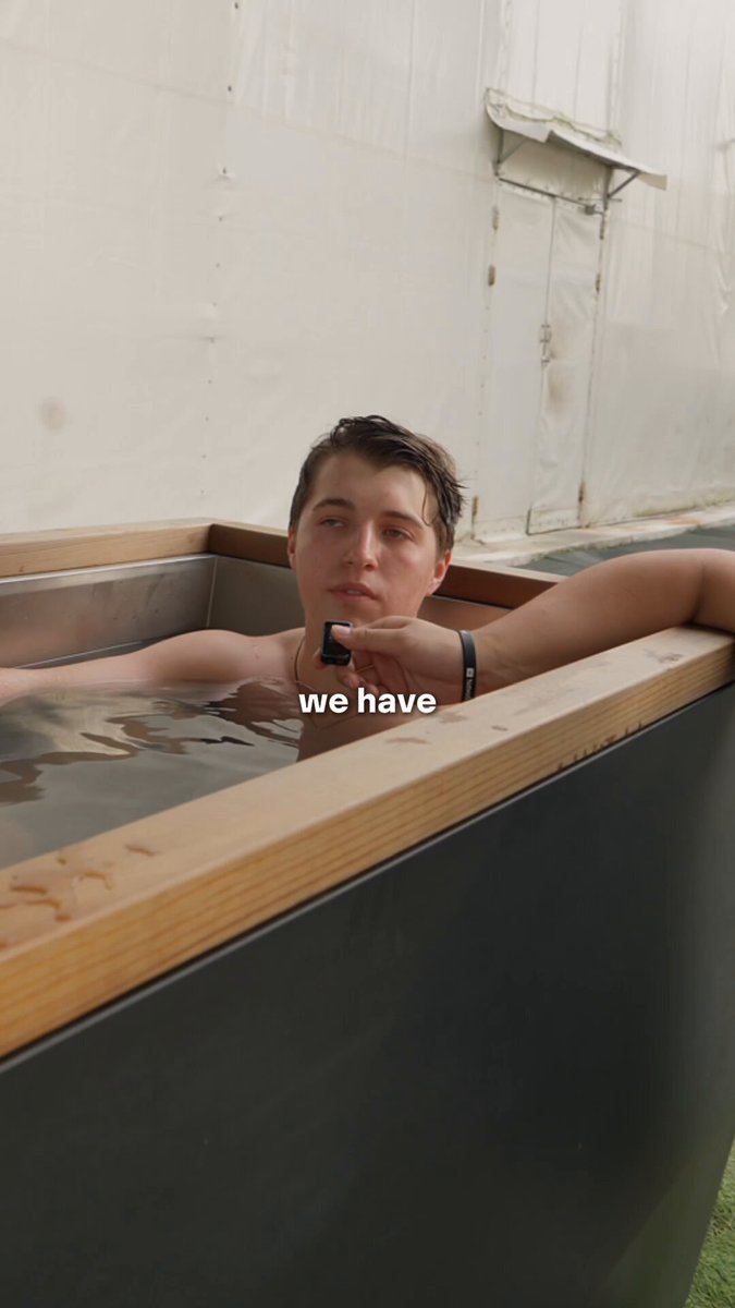 The image features a man sitting inside of a bathtub filled with water, wearing a watch around his neck. The photo has been captioned "We Have" above him, which suggests that this might be an interview or a story about the Base Founders Residency and their experiences at the event.