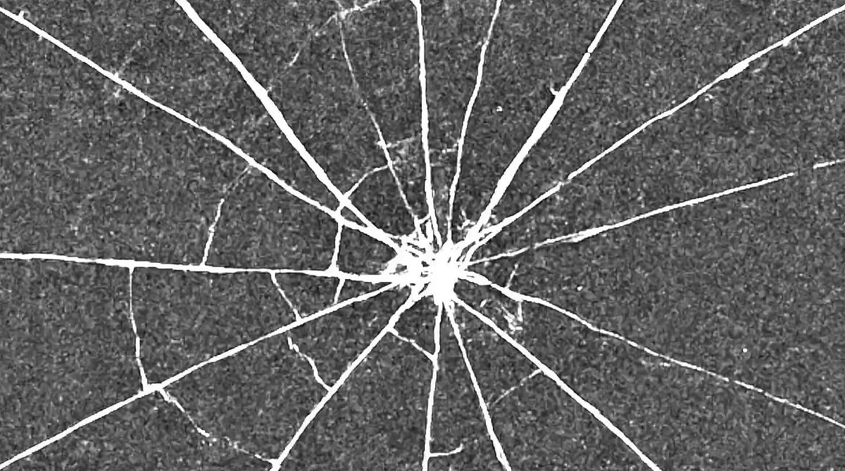The image shows a close-up view of a broken window, with white lines representing cracks or fractures. The background appears to be a dark gray color, which contrasts with the white lines of the broken glass. The caption above the image reads "Berlin will become the center of Solana energy this June." This suggests that the event is taking place in Berlin and is related to the Solana cryptocurrency project.