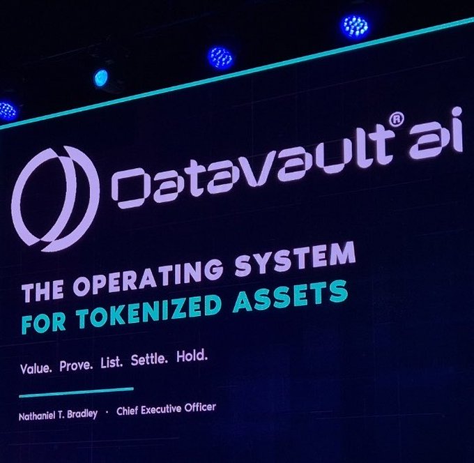 A large presentation screen displays the "DataVault AI" logo and branding alongside the tagline "THE OPERATING SYSTEM FOR TOKENIZED ASSETS" with the steps "Value. Prove. List. Settle. Hold." appearing below, crediting CEO Nathaniel T. Bradley. The image relates to the accompanying post by visually capturing Datavault AI's presentation at the XRP Seoul 2026 event, illustrating their pitch for how information can become a tradable asset on the XRP Ledger.