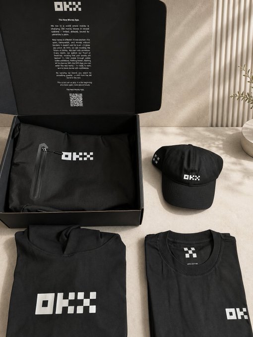 An unboxed 'OKX' branded merchandise gift set titled 'The Next Murky Age,' containing a black t-shirt, cap, and folded garments displayed on a beige surface.