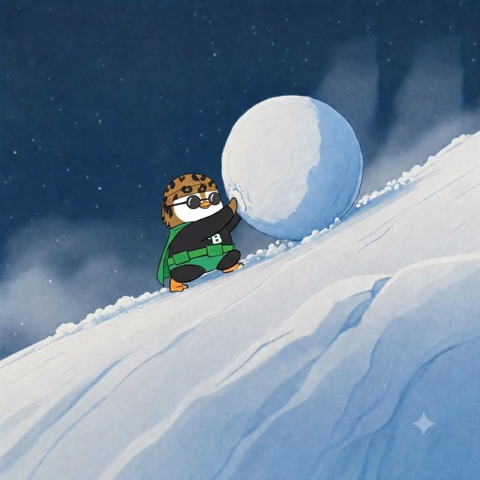 A penguin character wearing goggles, a tiger-striped hat, and a green utility belt rolls a giant snowball up a snowy hill under a starry night sky. The image captures the "keep pushing" sentiment from the post, showing determination and effort as the penguin tackles the uphill climb toward a goal.
