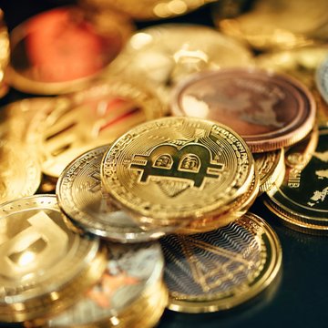 A close-up of assorted physical cryptocurrency coins, including a prominent gold coin featuring the "$NIGHT" Midnight logo and symbols, alongside Ethereum ($ETH) and tokenized stock coins, visually representing the post's claim that Midnight ($NIGHT) is bridging privacy-focused blockchain solutions across networks like Solana ($SOL) to meet growing private investor demand.