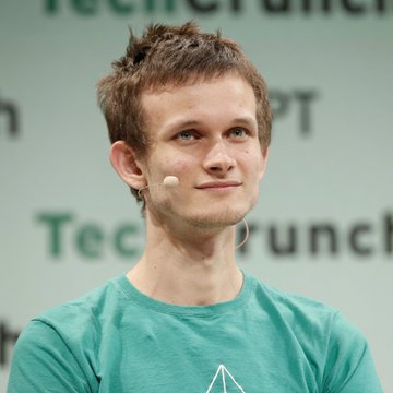 Vitalik Buterin, co-founder of Ethereum, speaks at a TechCrunch Disrupt event while wearing a headset microphone and a teal t-shirt. The image visually anchors the article about his remarks on obfuscation being the "final boss of cryptography" and the impracticality of current rigorous approaches, though the backdrop's partial "TechCrunch" and "Disrupt" text situates the setting rather than directly relating to the cryptographic discussion.