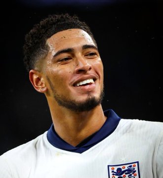 Jude Bellingham, wearing England's white away kit, smiles broadly during a match, his joy reflecting the standout performance that boosted his Golden Ball odds to 13% on Polymarket after his brace against Norway in the quarter-finals.