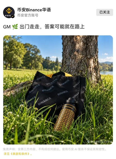A social media post from 币安Binance华语 featuring an image of Binance-branded merchandise including a black bag and a yellow patterned bottle resting against a tree in a grassy area.
