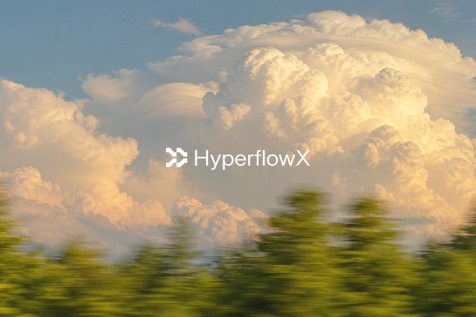 The image shows towering cumulus clouds against a blue sky, with blurred green trees in the foreground capturing a sense of motion. The text "HyperflowX" is overlaid on the clouds. The imagery of soaring clouds visually reinforces the post's theme of "flying" upward, symbolizing the smooth, frictionless performance of HyperflowX's automated trading.