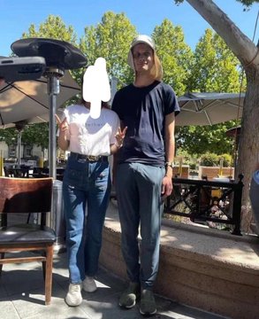 The image shows a man and a woman standing next to each other outdoors, both wearing white t-shirts with "vitalik" printed on them. There are also chairs visible around them, indicating an outdoor seating area or patio setting for dining. The text in the photo indicates that they have just attended an event or gathering at the University of Wyoming, as well as being part of a "herd of herders" group.
