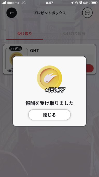 A Japanese mobile app notification showing receipt of a reward of x15877 coins with a flame icon, featuring a '受け取った' (received) message on a 'プレゼントボックス' (Present Box) screen.