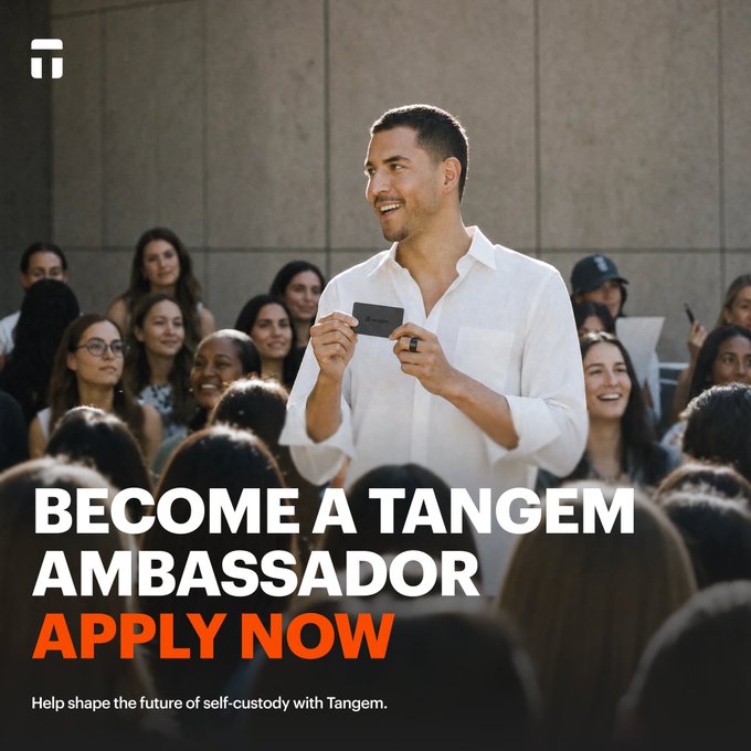 A promotional graphic for Tangem featuring a smiling man in a white shirt holding a card and speaking to a crowd, with the text 'BECOME A TANGEM AMBASSADOR APPLY NOW' and 'Help shape the future of self-custody with Tangem.'
