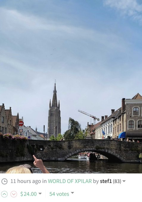 A scenic photo of a canal in Bruges, Belgium, featuring a stone arch bridge, historic buildings, and a tall Gothic church spire in the background, posted 11 hours ago in WORLD OF XPILAR by stef1 with 54 votes.