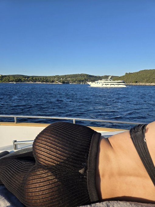 A person relaxes on a yacht with a large white boat in the background. The image relates to the post "there's always a bullrun somewhere" by depicting a luxurious lifestyle often associated with financial success.