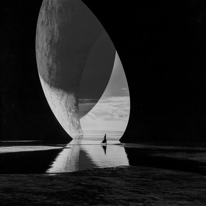 A black and white surreal image shows a small silhouetted figure walking through a massive circular opening between two dark structures, with a textured moon-like surface on the left and a cloudy sky beyond.