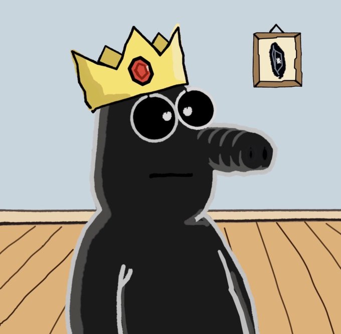 A cartoon illustration of a black character wearing a yellow crown with a red gem, standing in a room with wooden floors and a small framed picture on the wall.