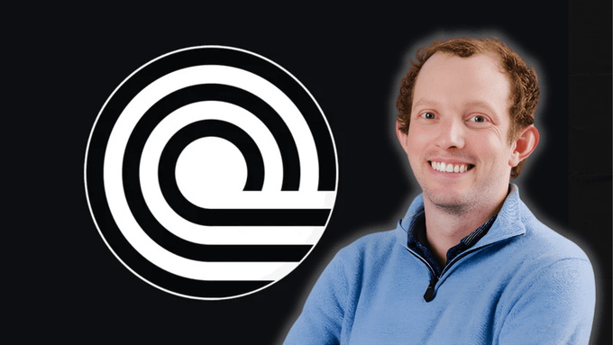 The image features a man wearing a blue sweater, smiling at the camera with his arms crossed. The background of the photo is black, which contrasts with the white logo that reads "Ondo Finance" in the center. The text "I feel like we look back in 10 years and put Nathan Allman on Mount Rushmore of RWAs He didn'qt just talk about tokenization He built real structure around it He pushed RWAs from narrative to real capital flows $3.8B+ in TVL on @OndoFinance OUSG > USDY". The man's pose and the logo create a sense of nostalgia, as if they are looking back at an era when tokenization was a hot topic in the financial world.