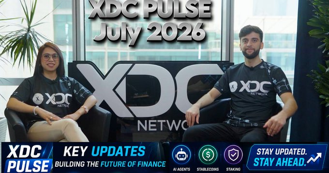 A thumbnail for a video titled 'XDC Pulse July 2026' featuring a man and a woman in matching XDC Network shirts seated in a studio setting.